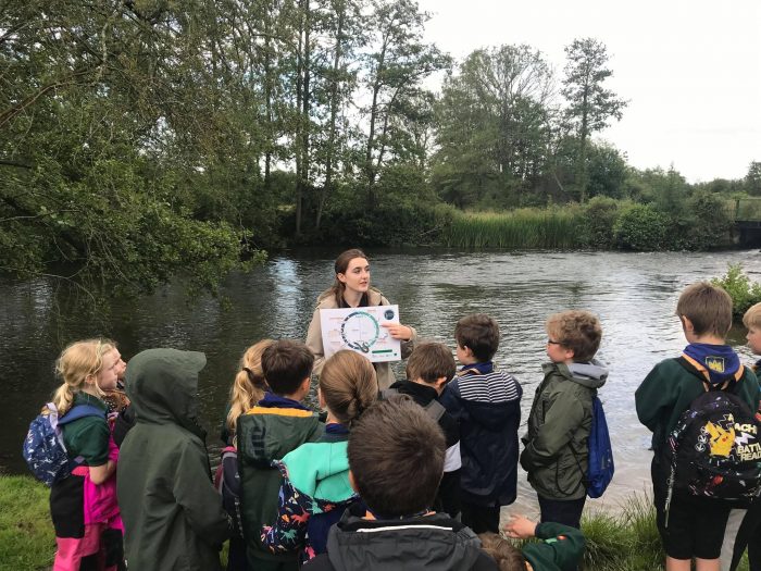 Kids by river with eel lifecycle
